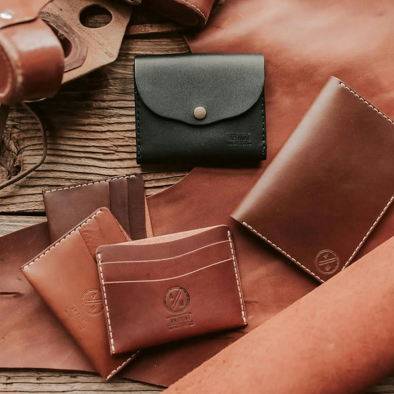 Collection of leather wallets on a wooden surface